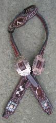 Dark mahogany leather with inlaid giraffe print hair on cowhide. Antique copper dots, buckles and conchos.
